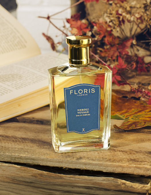 A bottle of 'Neroli Voyage' surrounded by autumn foliage.