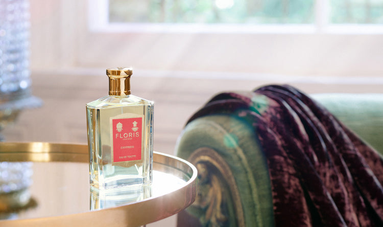 A bottle of Chypress placed on a mirrored table in a sunlit room.