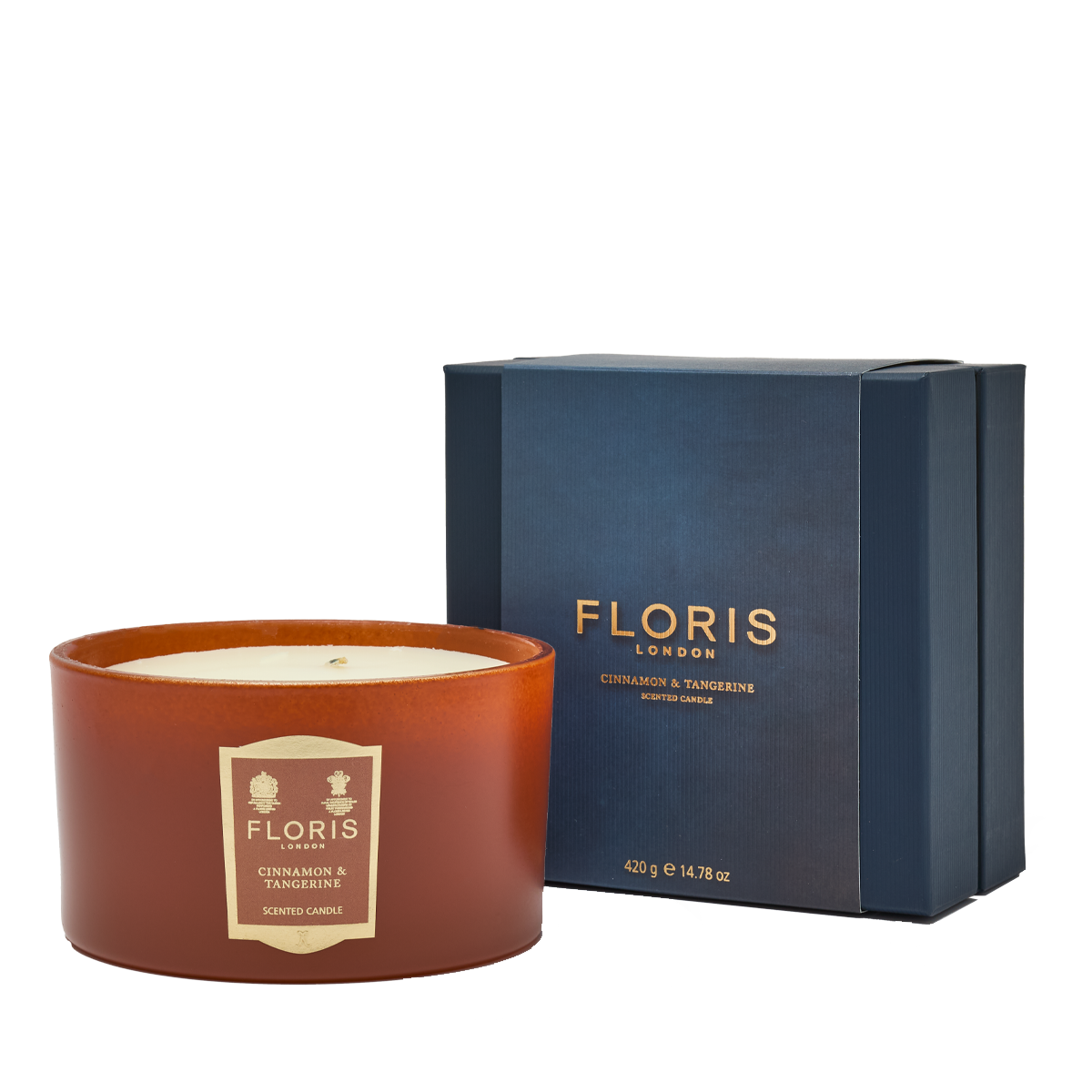 The Floris London Cinnamon & Tangerine Deluxe Three Wick Candle sits beside a navy blue box labeled "Cinnamon & Tangerine.
