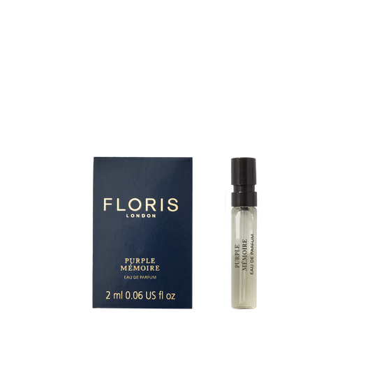 A 2ml Floris London Purple Mémoire - Eau de Parfum vial rests beside its dark blue box—a refined scent evoking classic English elegance.