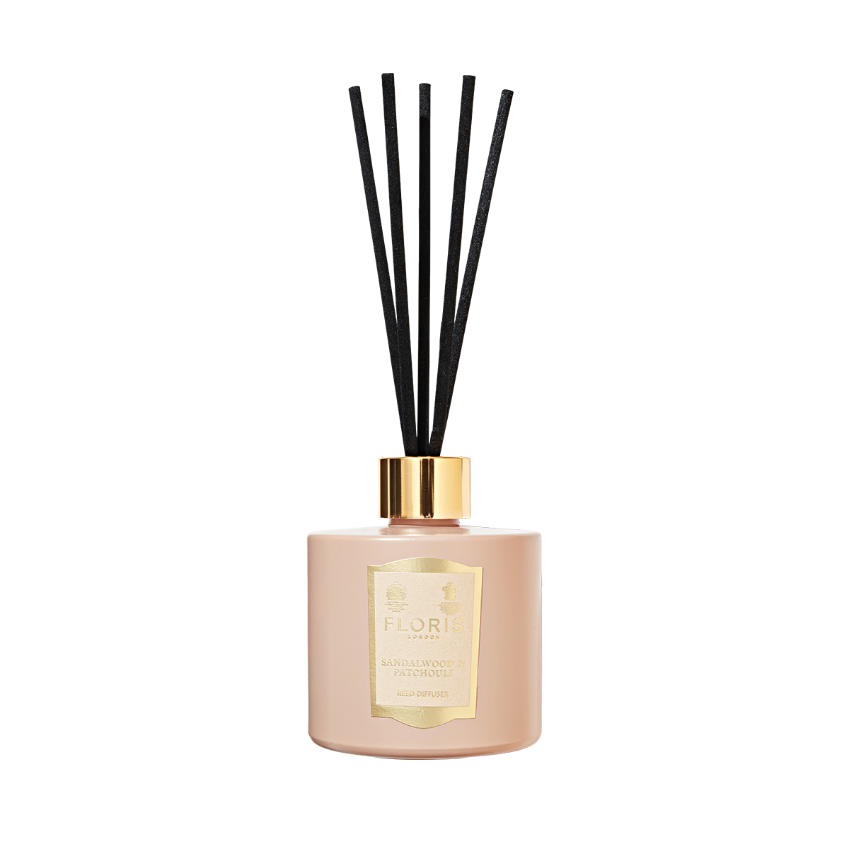 The Sandalwood & Patchouli Reed Diffuser by Floris London features a woody amber scent with rose and jasmine notes in a pink vessel with black sticks.