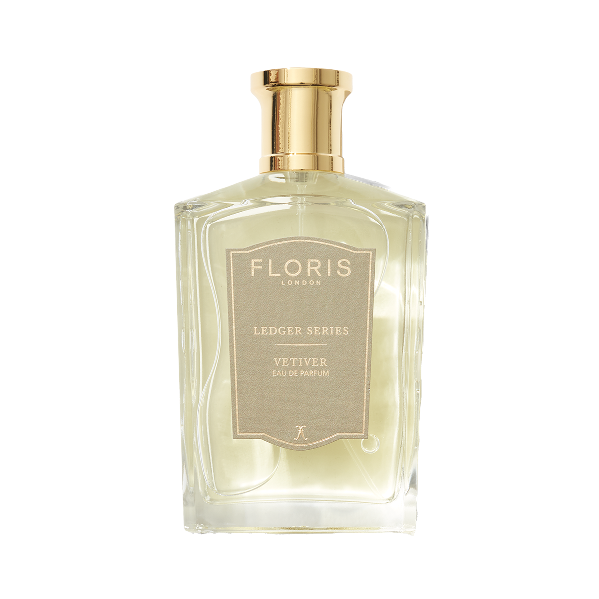 A clear glass bottle of Floris London Vetiver Eau de Parfum features a gold cap and beige label, capturing a grounding, earthy scent.
