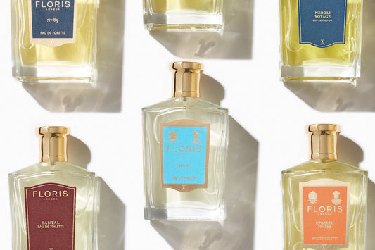 An arrangement of five Floris London fragrance bottles on a light background. Each bottle has a distinct colored label, including blue, red, and orange, displaying names like 'No. 89,' 'Neroli Voyage,' 'Santal,' 'Sirena,' and 'Special No. 127.' The bottle