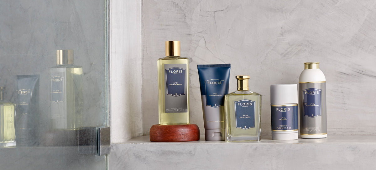 A collection of Floris toiletries with red labels arranged on a green marble bathroom counter.