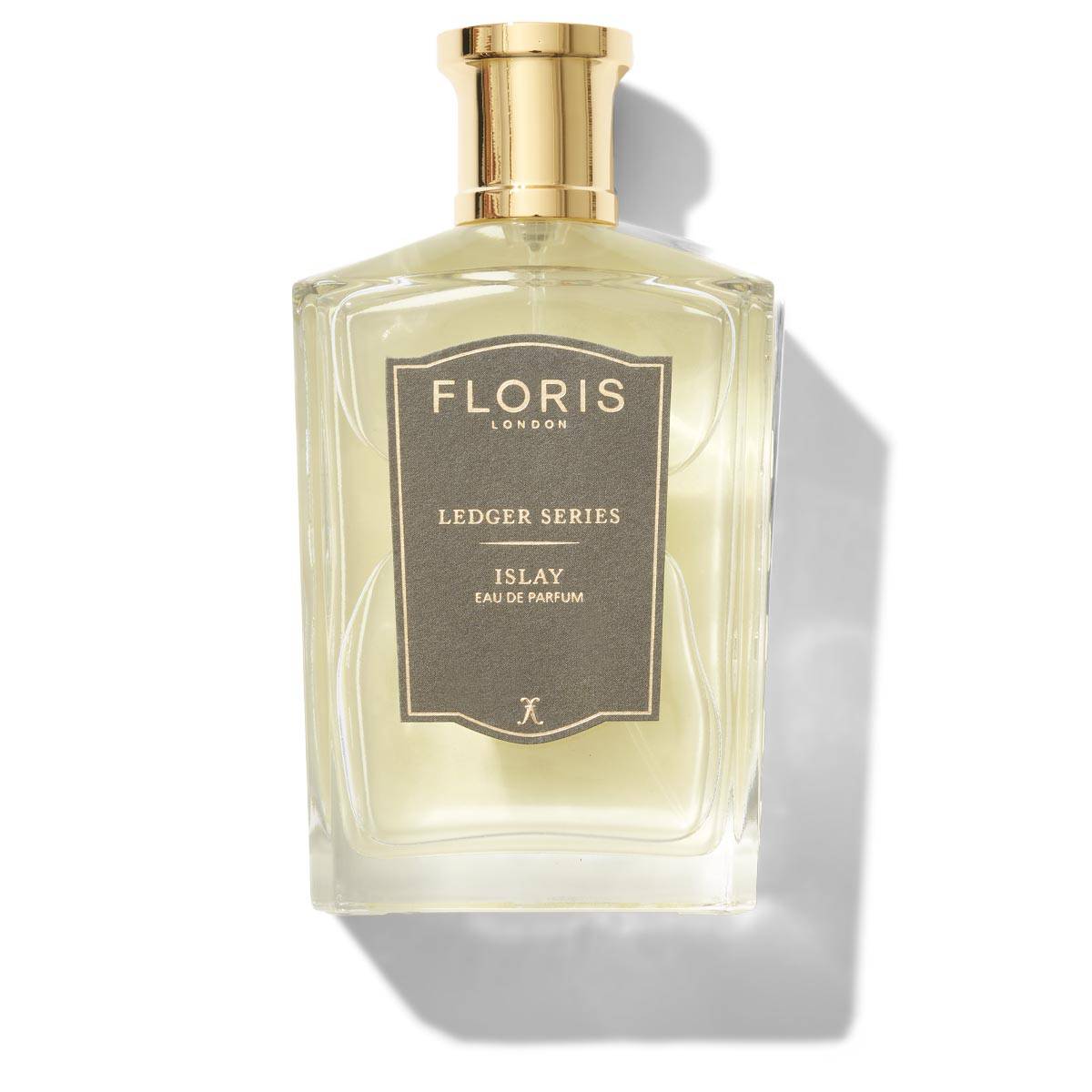 A bottle of Floris London Islay Eau de Parfum, featuring a golden cap and a gray label, enhanced by the invigorating notes of bergamot.