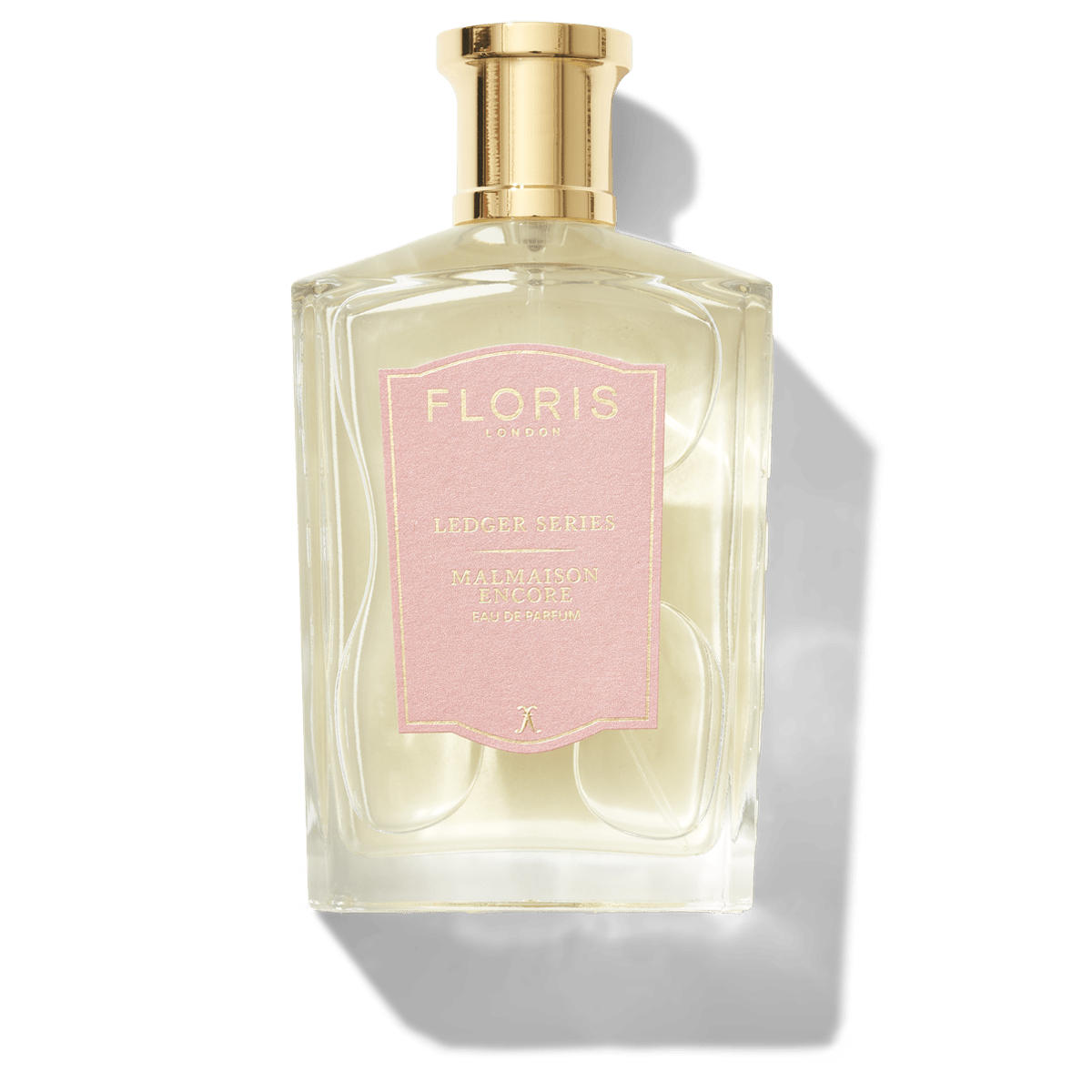 A clear glass perfume bottle with a gold cap and a pink label beautifully showcases "Floris London," "Ledger Series," and "Malmaison Encore." This floral oriental fragrance exudes a captivating allure.