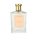 A clear Floris London bottle with a gold cap and peach label reads "Bouquet de La Reine - Eau de Toilette," a luxury fruity floral scent.