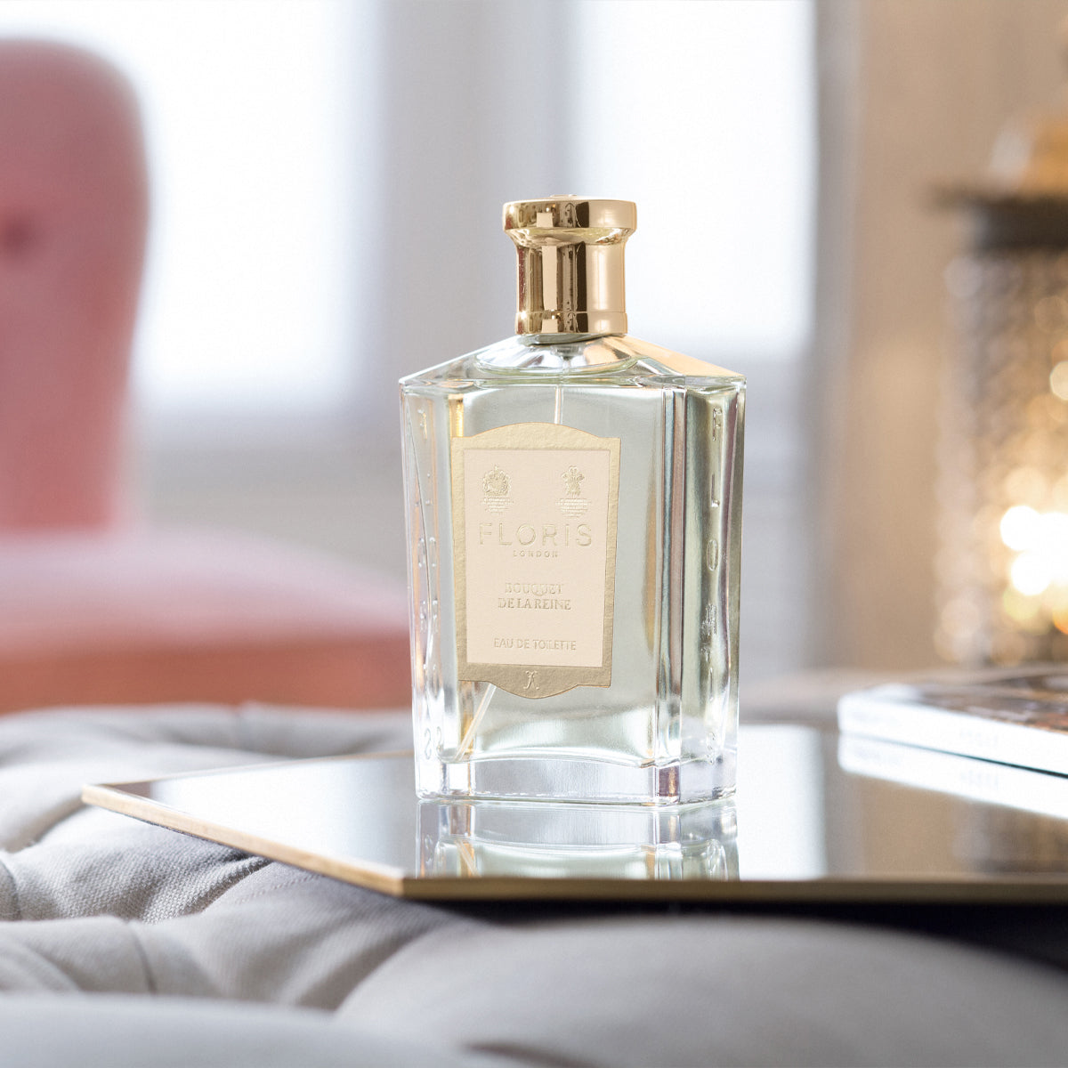 Bouquet de La Reine by Floris London: an elegantly designed bottle with a gold cap, exuding a fruity floral aroma on a reflective surface in soft light.