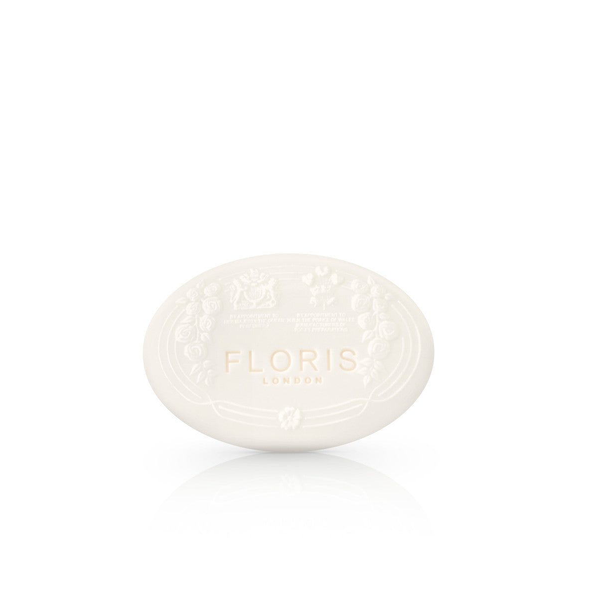 White Rose - Luxury Soap features an ivory oval shape with an embossed floral design, "Floris London" text in gold on the front, and a hint of shea butter.