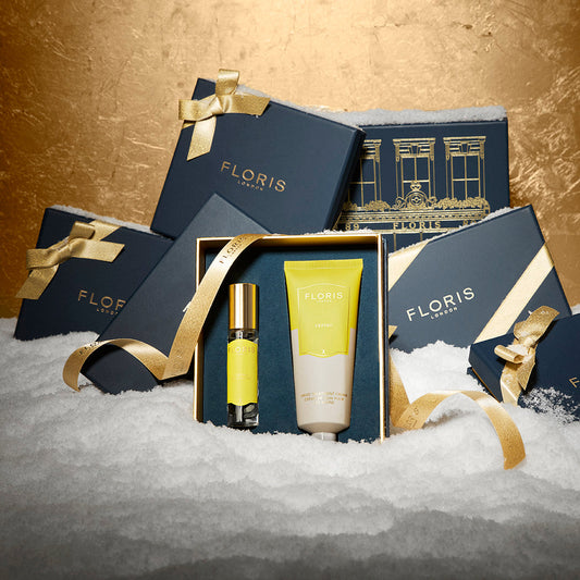 Cefiro Hero and Cefiro Duo gift boxes by Floris London US in snow, surrounded by navy and gold ribbon-wrapped packages.