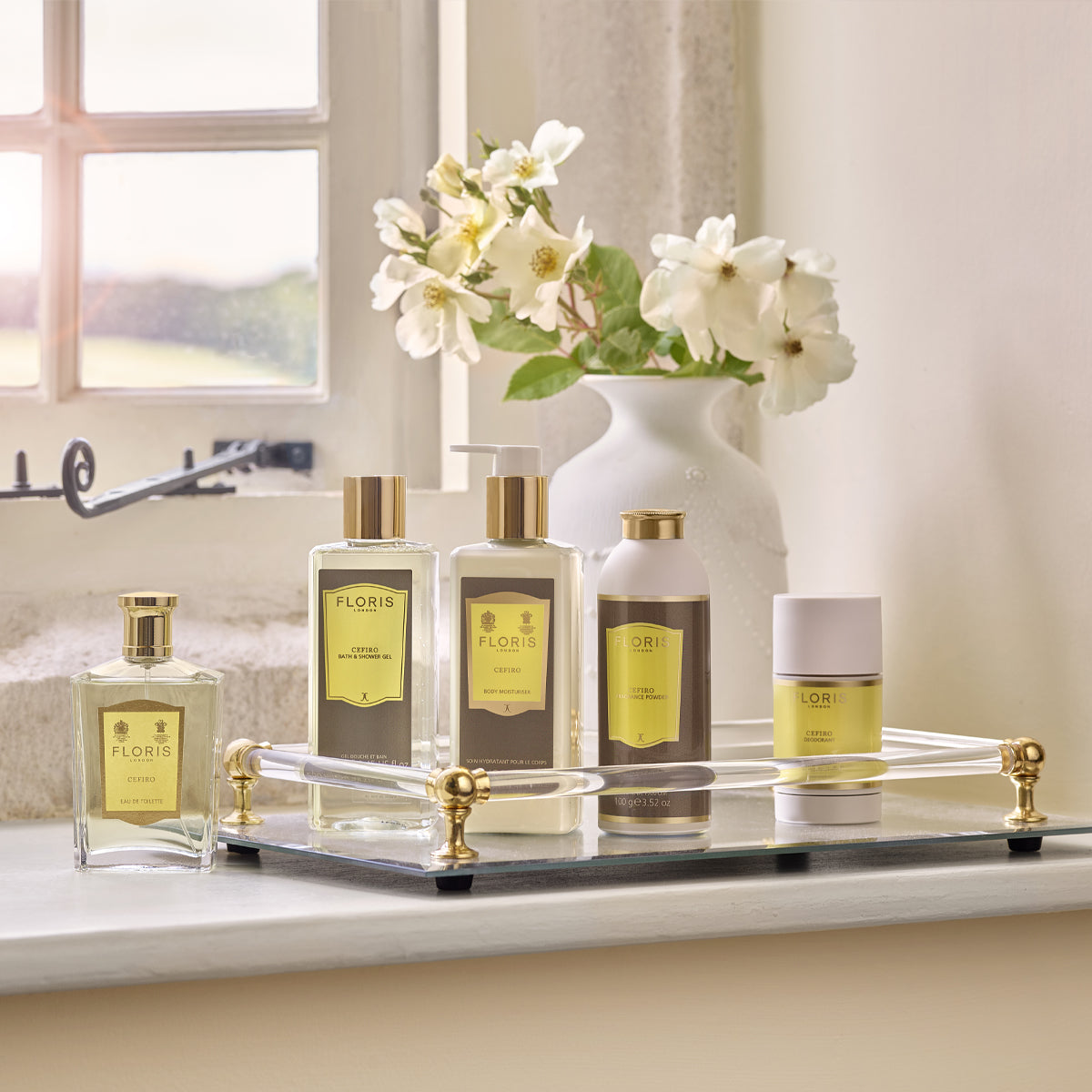 Floris London's Cefiro - Eau de Toilette is a unisex fragrance with notes of jasmine, lemon, and lime, elegantly placed near a window with white flowers.