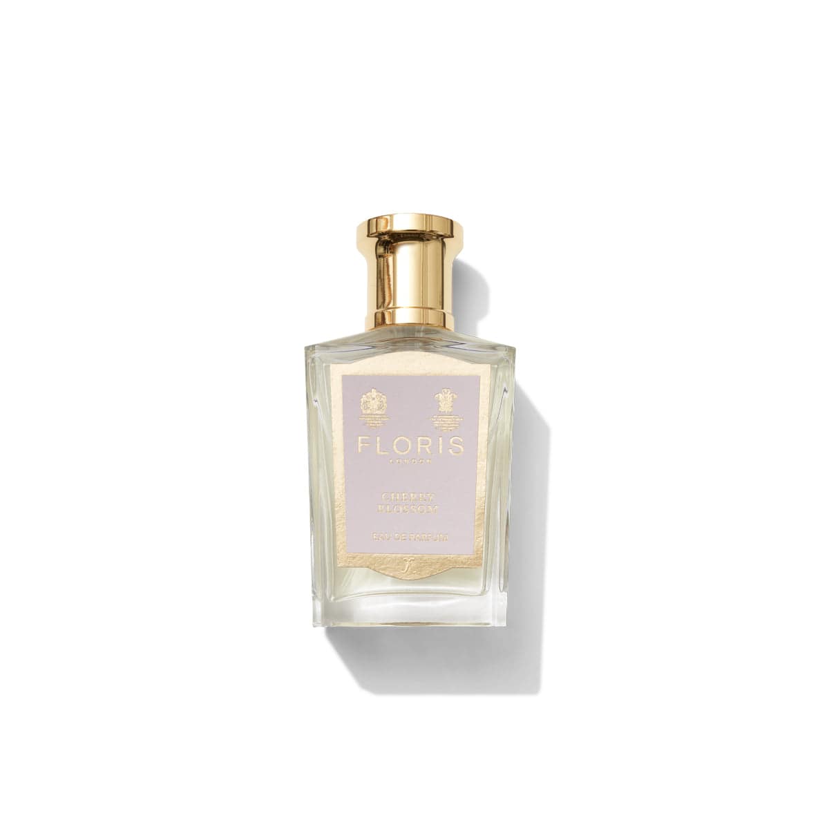 A bottle of Floris London Cherry Blossom - Eau de Parfum, adorned with a gold cap and label, showcasing elegant branding in a clear, rectangular design, is perfect for self-care with its delightful floral-fruity fragrance.