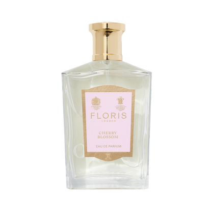A clear glass bottle of Floris London Cherry Blossom - Eau de Parfum with a gold cap and pink label, capturing the cherry blossom fragrance.