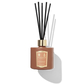 Orange diffuser bottle with reeds coming out of the top