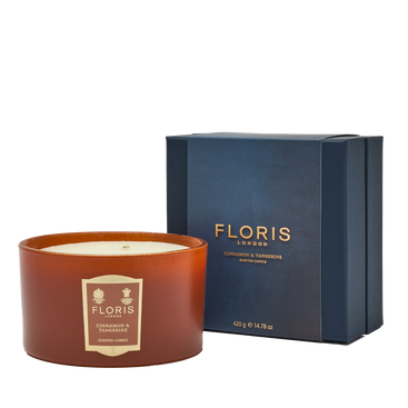 The Floris London Cinnamon & Tangerine Deluxe Three Wick Candle sits beside a navy blue box labeled "Cinnamon & Tangerine.