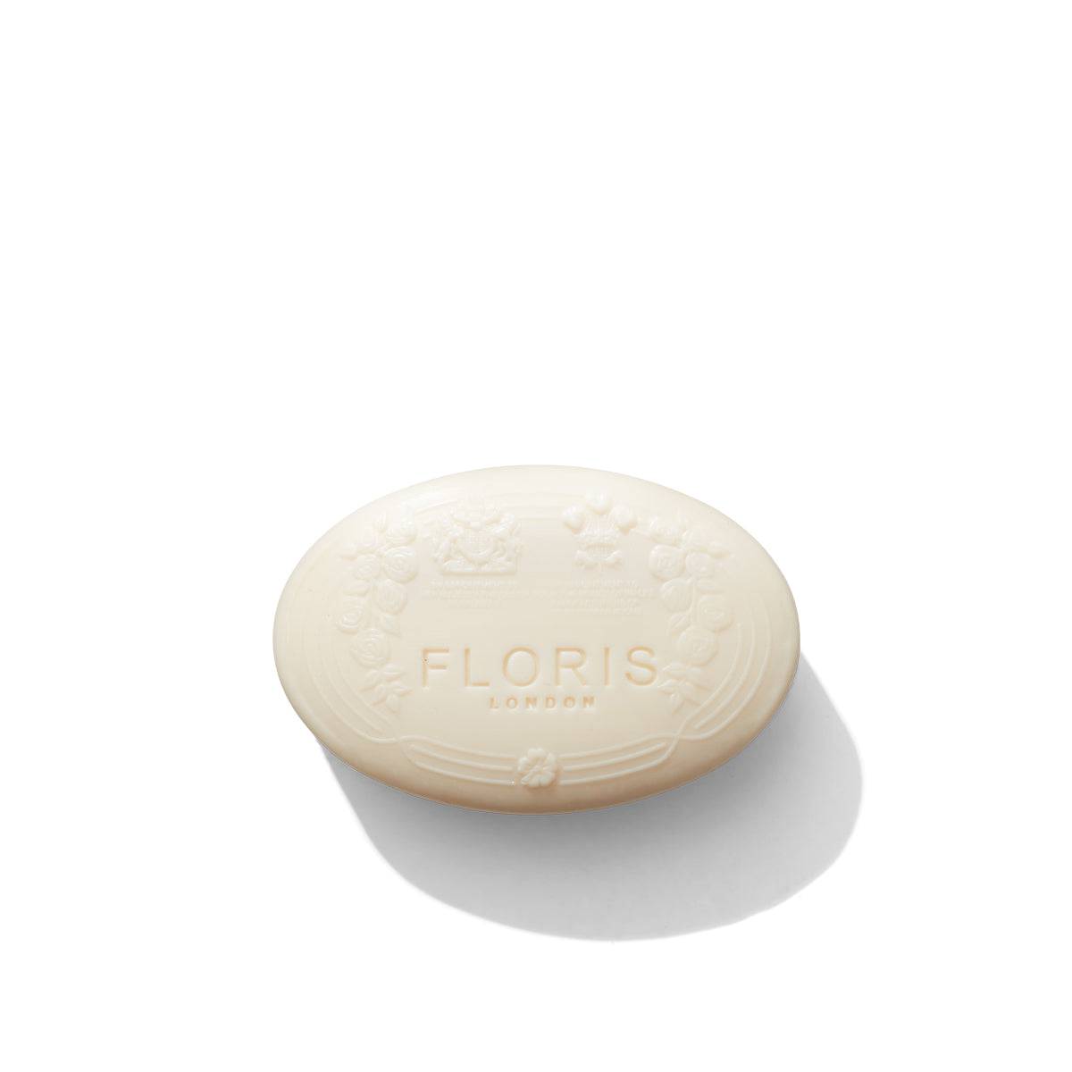 Oval-shaped white "Elite - Luxury Soap" bar by Floris London, featuring an embossed design and photographed on a white background with a soft shadow, enriched with shea butter for a luxurious feel.