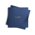 A square-shaped booklet with a navy blue cover featuring the gold-embossed text 'FLORIS LONDON' cantered on the front.