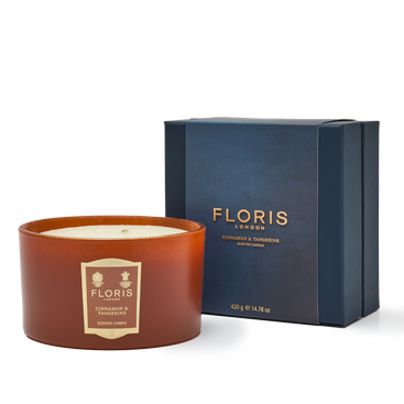 A limited-edition Cinnamon & Tangerine Deluxe Three Wick Candle from Floris London, placed next to its navy blue packaging box.