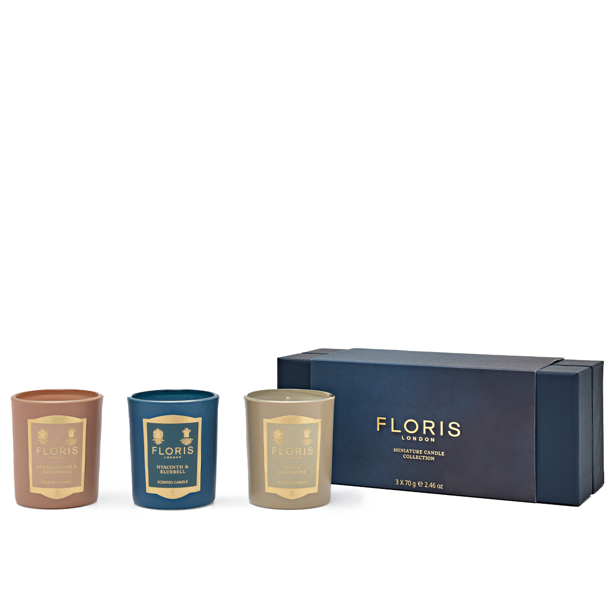 Three beautiful candles from the Floris London Miniature Candle Collection in brown, teal, and ivory rest elegantly beside a blue and gold packaging box.