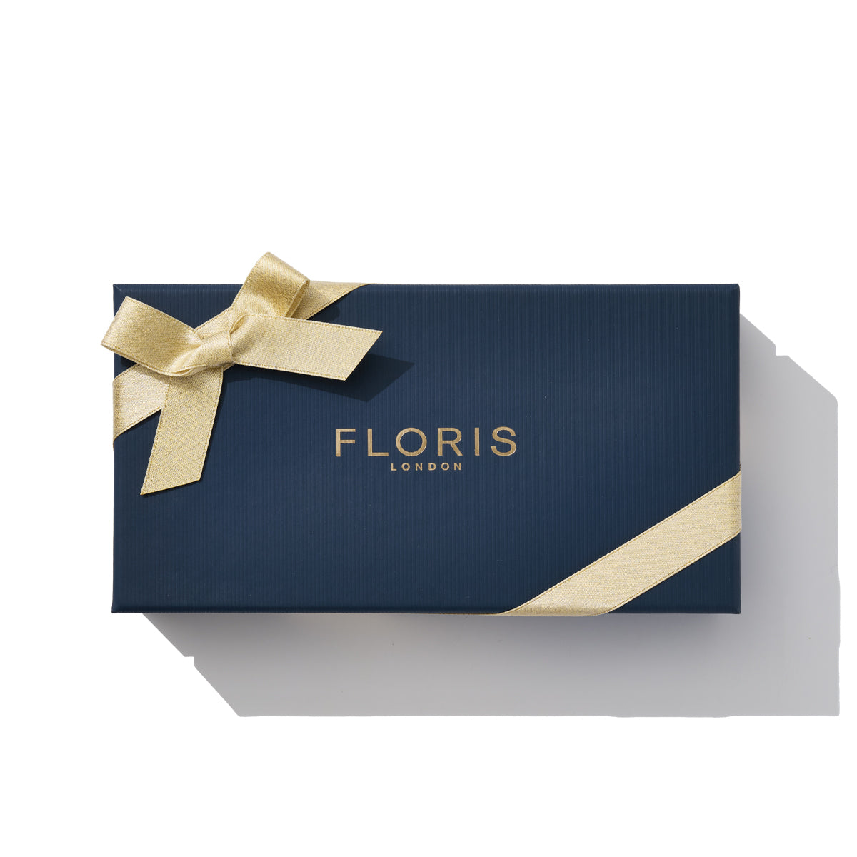 Navy gift box with gold ribbon, emblazoned with "Floris London" on top, subtly suggesting the sophistication of the "Soap Collection | For Him," enriched with jasmine notes.