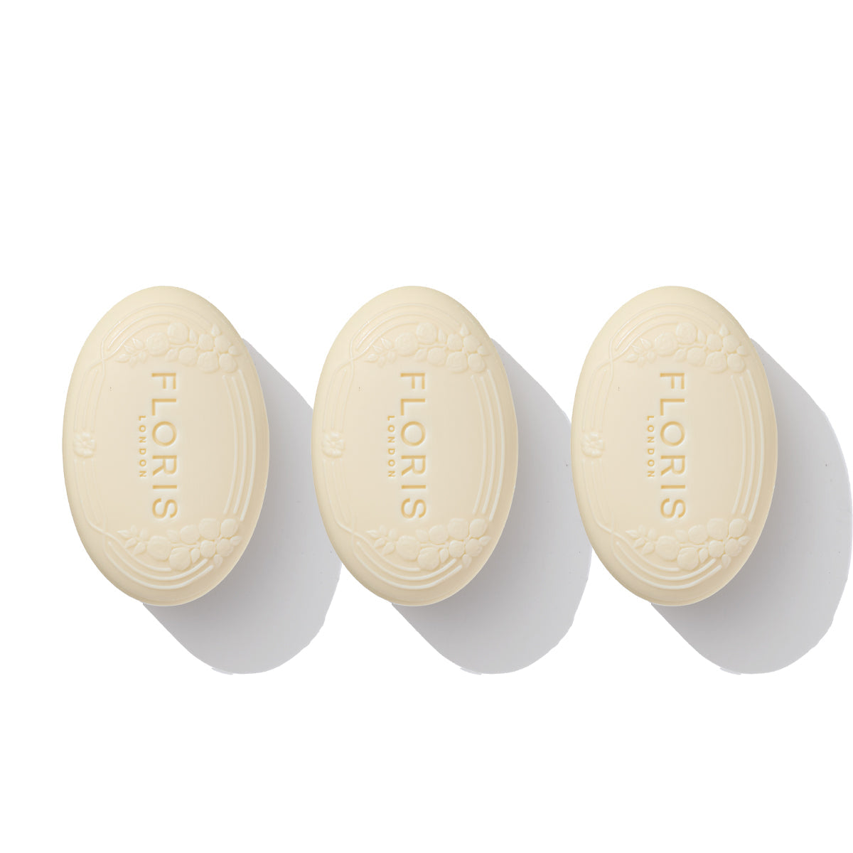 A trio of oval soaps from Floris London's Soap Collection for Him, engraved with "FLORIS LONDON" on a white background and casting gentle shadows, releases the delicate essence of jasmine.
