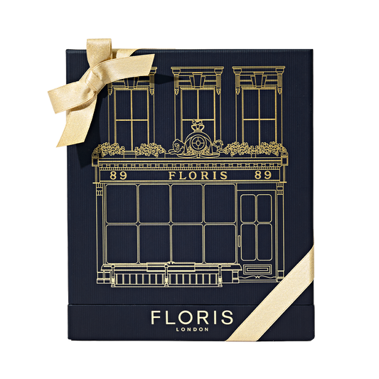 Floris London US "The Icon | No. 89 Duo" gift box in navy with gold building illustration, logo, and finished with a gold ribbon bow.
