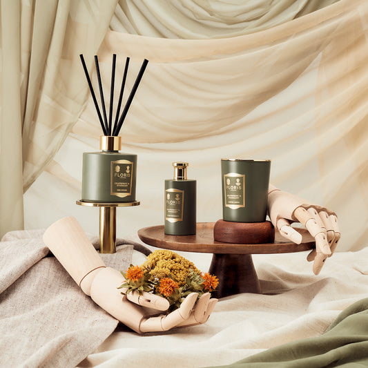 Floris London Grapefruit & Rosemary Reed Diffuser 200ml, displayed with wooden hands, flowers, and draped fabric in an elegant aromatherapy setting.