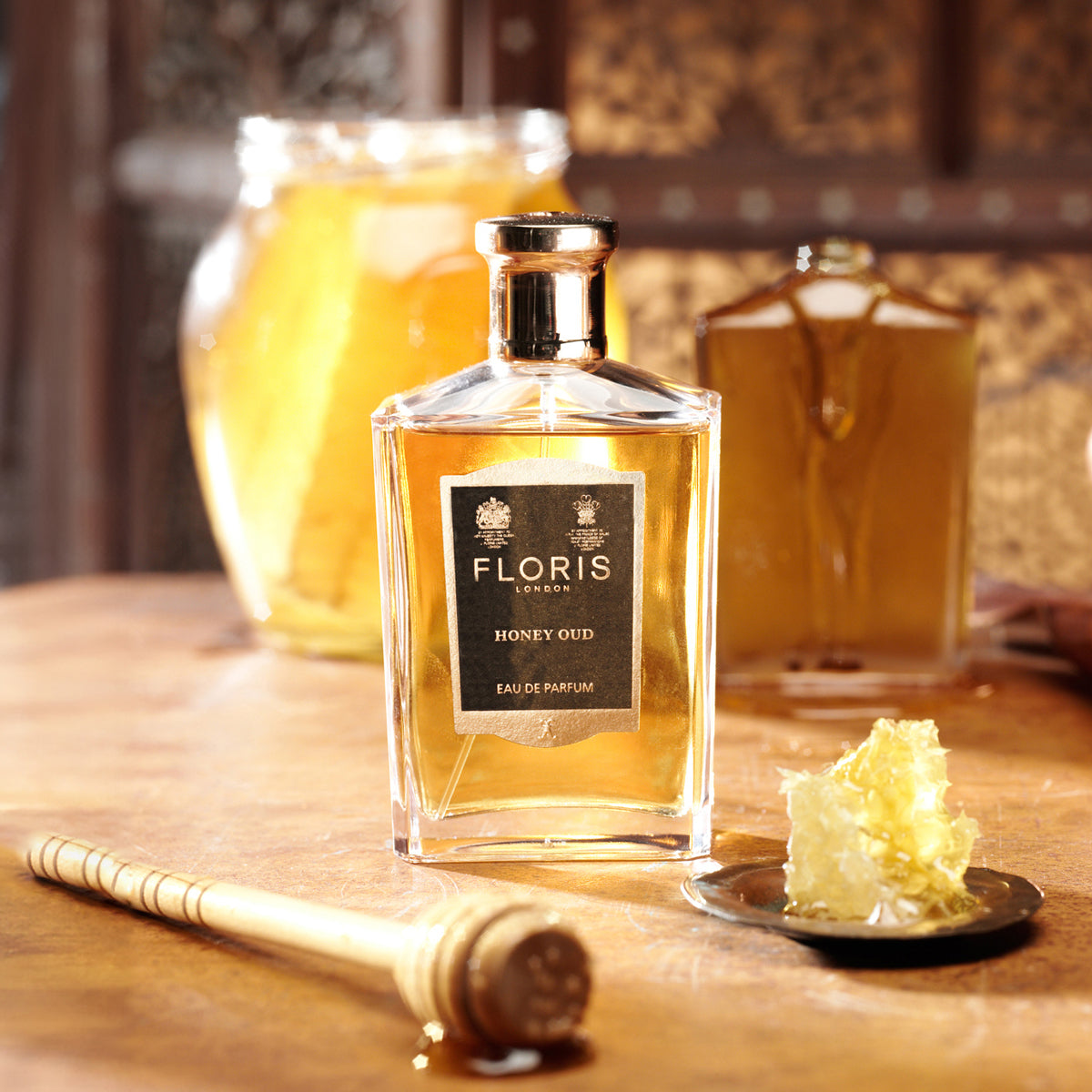 Floris London's Honey Oud - Eau de Parfum bottle is nestled among honeycomb and a dipper, exuding the rich essence of oud oil.