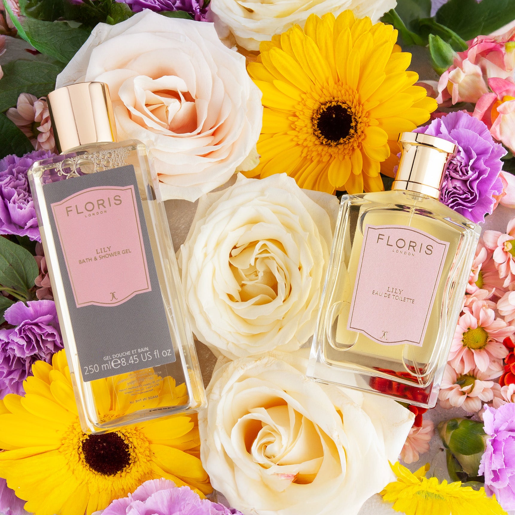 Floris London Lily Mother’s Day Pairing bottles set among vibrant fresh flowers, like roses and daisies.