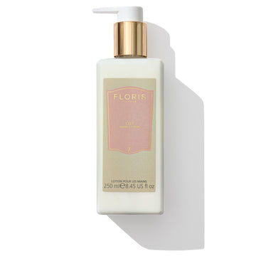 A bottle of Lily Luxury Hand Lotion by Floris London, equipped with a pump, adorned with a pink label and a gold cap, and containing 250 ml (8.45 fl oz), exudes an uplifting and warm, balanced floral fragrance that leaves a lingering trail.