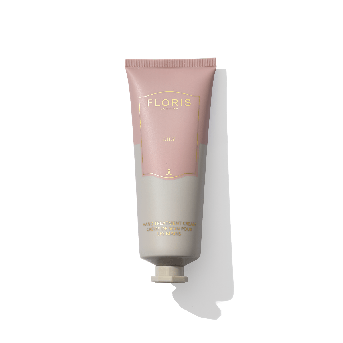 A tube of Floris London's Lily - Hand Treatment Cream, encased in minimalist packaging with soft pink and beige colors. This cream exudes an uplifting floral fragrance, leaving a lingering trail of elegance.