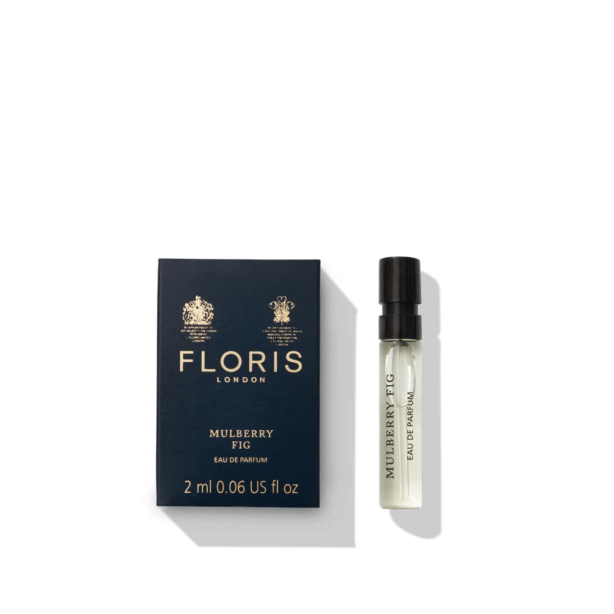 A 2 ml bottle of Floris London Mulberry Fig - Eau de Parfum, showcasing its delicate floral amber fragrance, sits elegantly beside its navy-blue box.