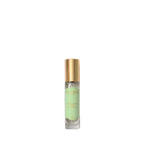 A small glass perfume bottle with a gold cap and a light green Floris London label, featuring Mulberry Fig - Eau de Parfum with a woody scent.