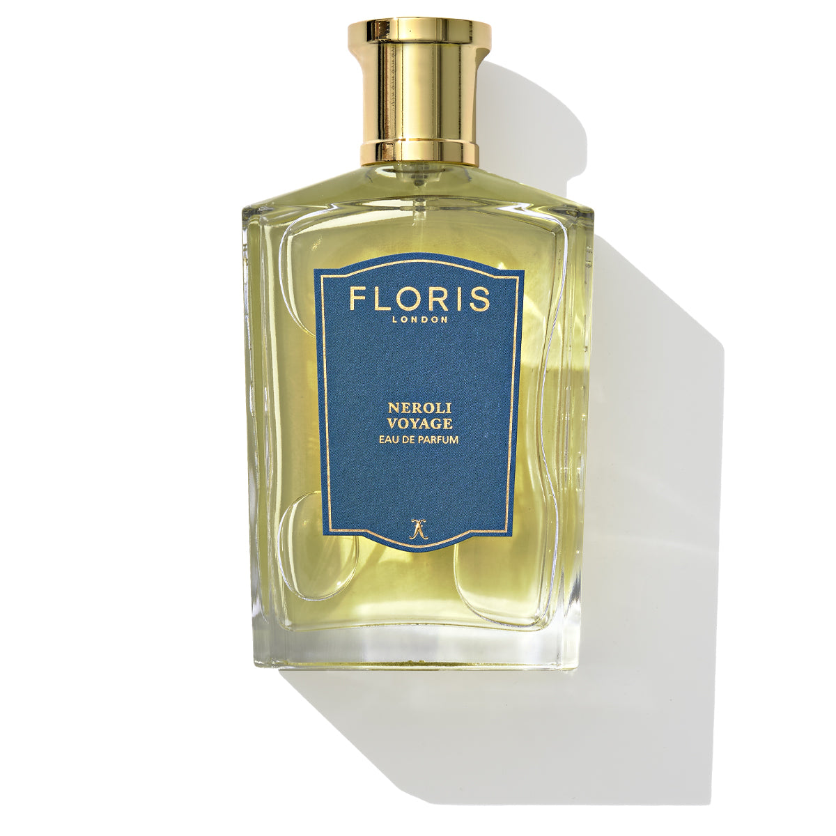 A bottle of Floris London's Neroli Voyage Eau de Parfum featuring a gold cap and a blue label, casting a shadow on a white background. This unisex fragrance boasts a refreshing blend of neroli and citrus marine notes.