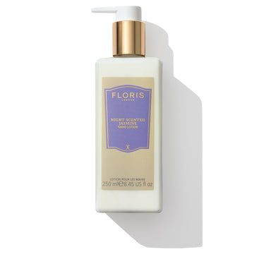 A bottle of Floris London Night Scented Jasmine - Hand Lotion, featuring a white pump and a gold cap, enriched with vitamin E and sweet almond oil, comes labeled in lavender and gold.