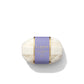 A luxury soap from Floris London, wrapped in white paper with a purple and gold label that reads "Night Scented Jasmine," releases a captivating floral fragrance.