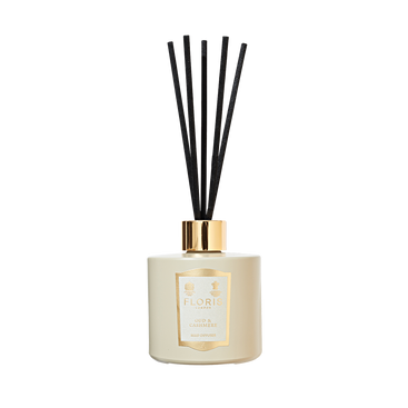 A cream reed diffuser with black sticks and a gold “Floris London” label—Oud & Cashmere is a timeless home fragrance accent.