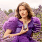 A woman in a purple dress holds Floris London's Purple Mémoire - Eau de Parfum amid lavender fields, capturing its essence.