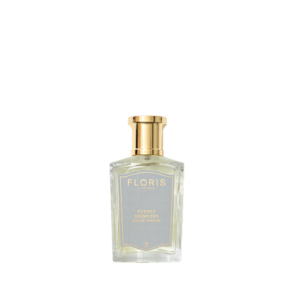 A clear glass Purple Mémoire Eau de Parfum bottle by Floris London, with a gold cap and elegant label, exudes English charm and sophisticated scent.