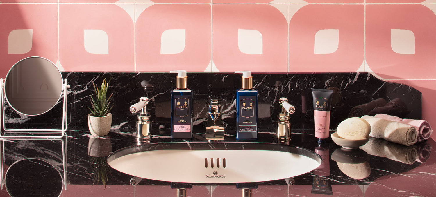 A pink tiled bathroom with Rosa Centifolia Floris London products on a marbled counter