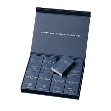An open Floris London Sample Set box displaying eight small navy blue perfume bottles.