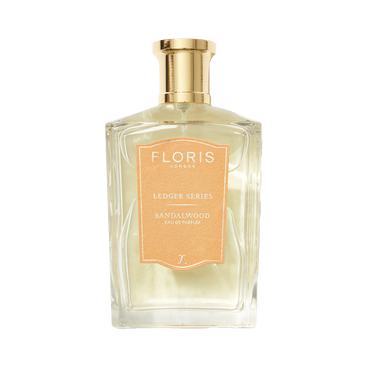 A clear glass bottle of Floris London Sandalwood with a gold cap and orange label, offering a timeless woody fragrance.