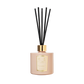 The Sandalwood & Patchouli Reed Diffuser by Floris London features a woody amber scent with rose and jasmine notes in a pink vessel with black sticks.