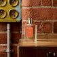 A bottle of Floris London Special No. 127 Eau de Toilette sits on wood by a brick wall, evoking British perfumery with citrus and floral fragrance notes.