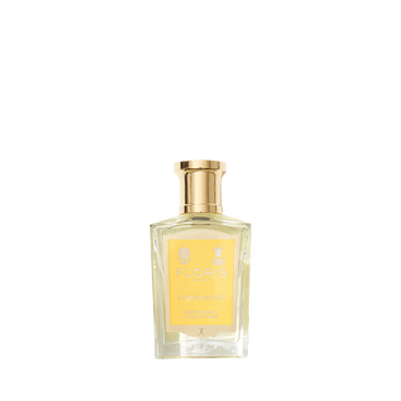 A clear glass bottle of Floris London Stephanotis Bath Essence with a gold cap and yellow label, showcasing its floral essence on a white background.