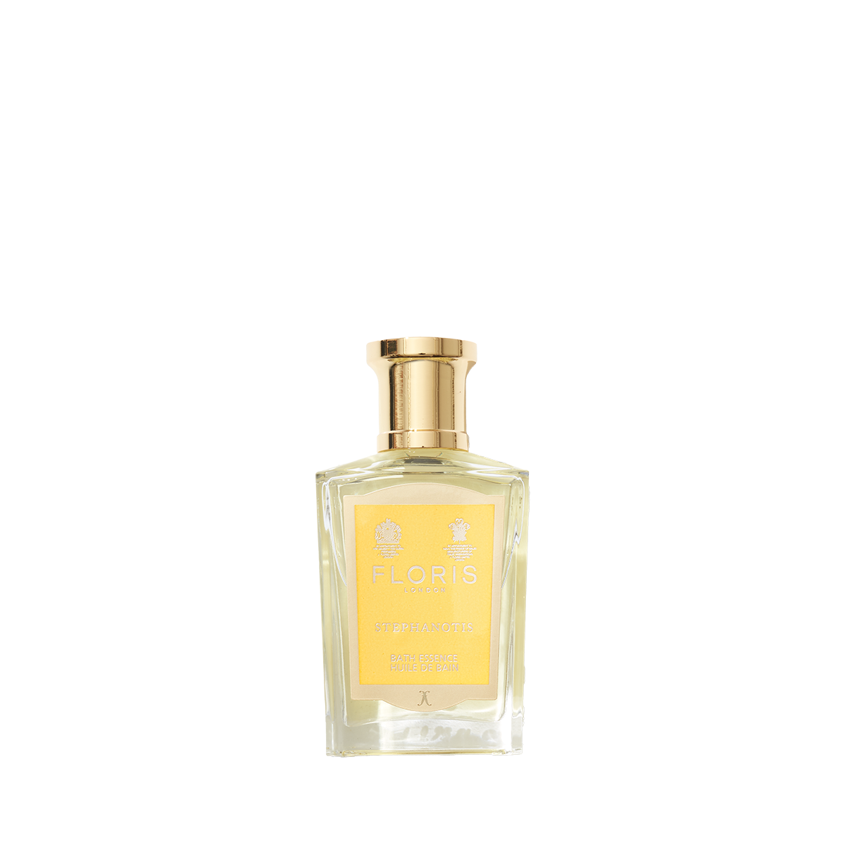 A clear glass bottle of Floris London Stephanotis Bath Essence with a gold cap and yellow label, showcasing its floral essence on a white background.
