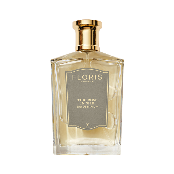 A clear glass bottle of Floris London Tuberose in Silk - Eau de Parfum, a luxurious fragrance with a gold cap and gray label.