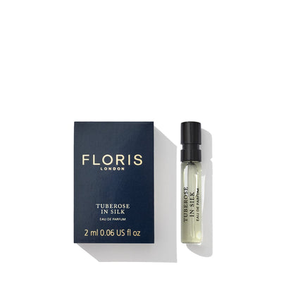 A sample of Floris London’s Tuberose In Silk - Eau de Parfum, with the bottle positioned next to its box under bright light casting shadows, capturing the essence of a delicate fragrance with notes of tuberose and jasmine.