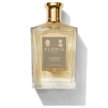 An elegant glass bottle of Floris London's Tuberose In Silk - Eau de Parfum, adorned with a gold cap and label, featuring an exquisite blend of tuberose and jasmine.