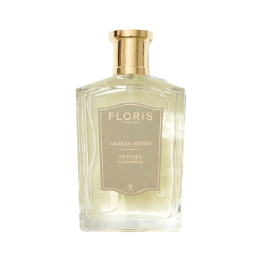 A clear glass bottle of Floris London Vetiver Eau de Parfum features a gold cap and beige label, capturing a grounding, earthy scent.